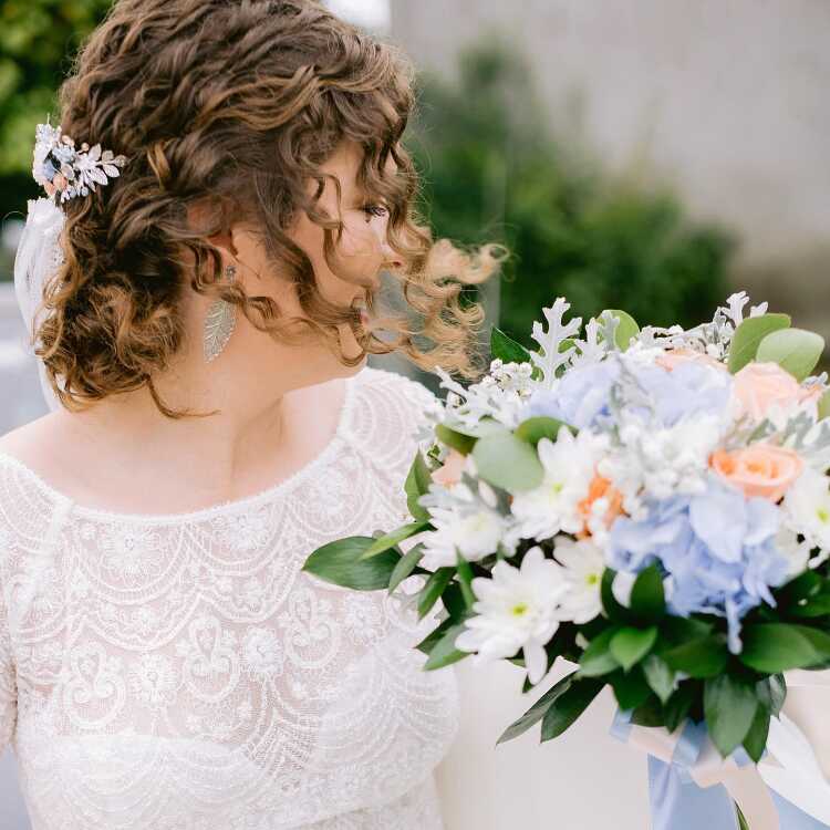 Bride with Leaf Earrings and Flower Arrangement at Wedding